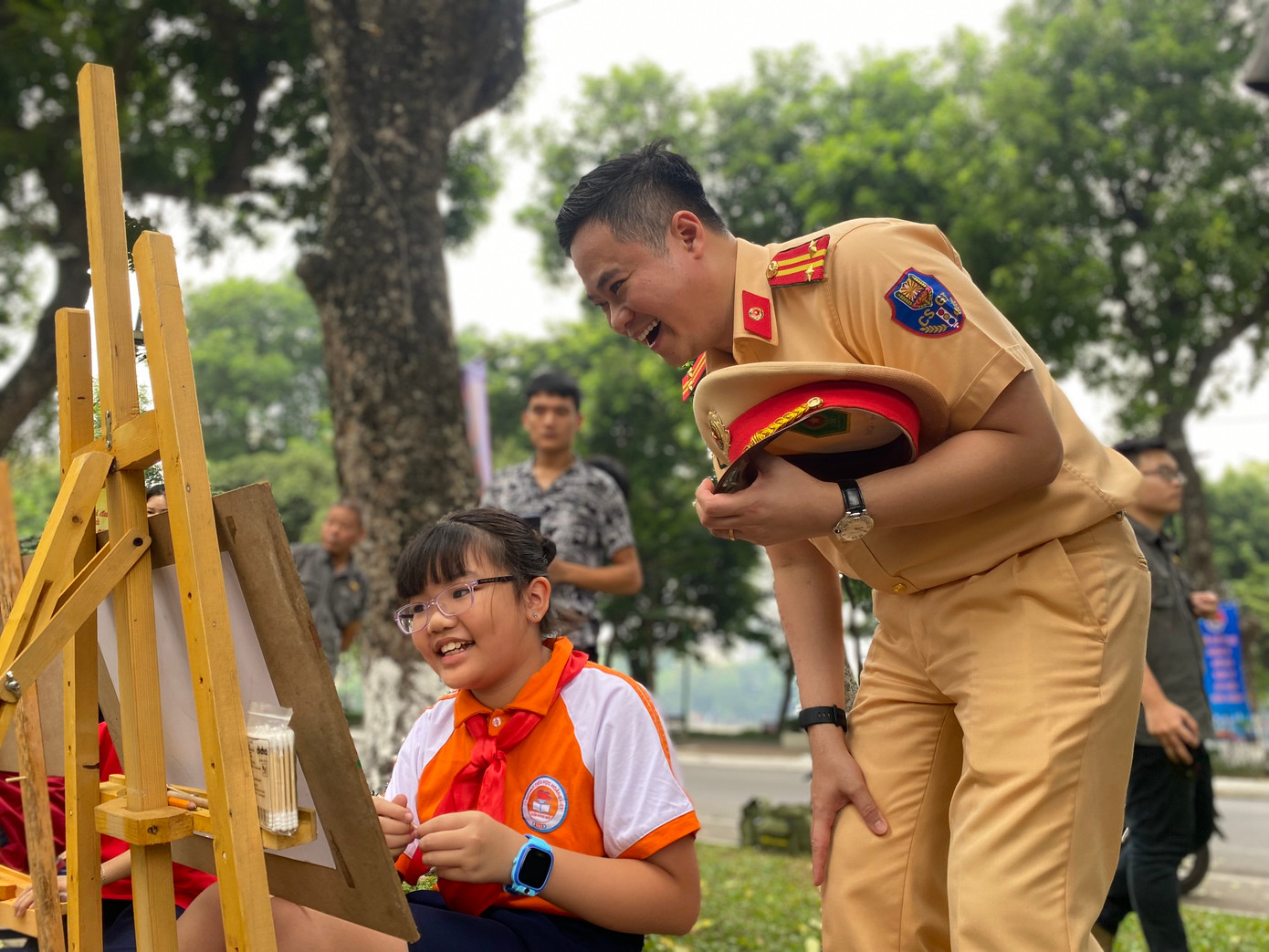 Cảnh sát giao thông Hà Nội chia sẻ niềm vui với các em thiếu nhi Thủ đô vẽ tranh về an toàn giao thông tại Ngày hội. Ảnh: Bảo Anh