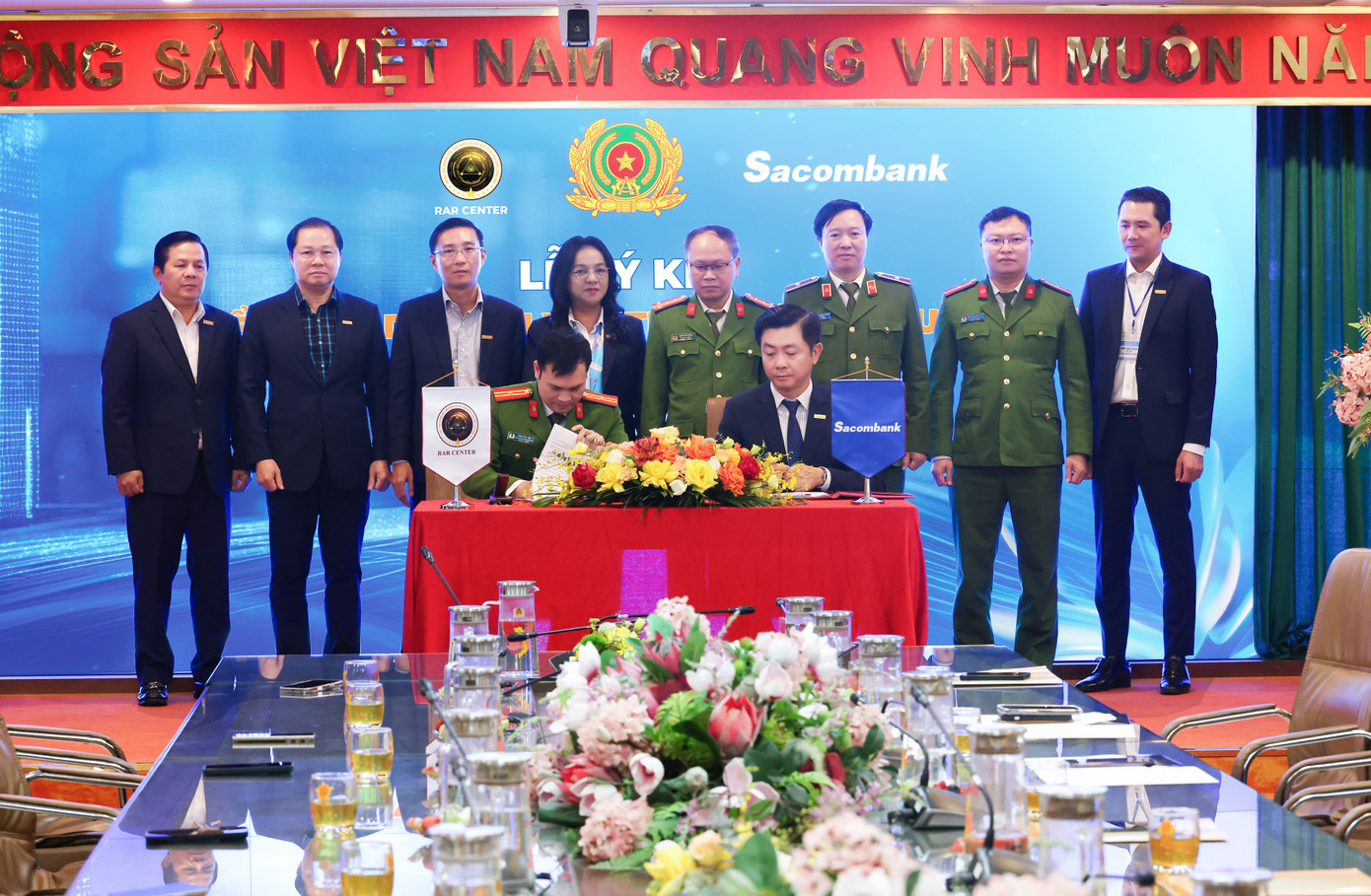 Với sự phối hợp giữa Trung tâm RAR và Sacombank, việc triển khai dịch vụ xác thực điện tử qua VNeID sẽ không chỉ giúp người dân dễ dàng thực hiện các giao dịch tài chính mà còn góp phần bảo vệ an toàn thông tin và giảm thiểu rủi ro gian lận trong các giao dịch trực tuyến. Đại diện ký kết: Ông Phan Đức Hiệp – Phó giám đốc Trung tâm nghiên cứu ứng dụng dân cư và căn cước công dân và ông Nguyễn Minh Tâm – Phó Tổng giám đốc Sacombank. Với sự phối hợp giữa Trung tâm RAR và Sacombank, việc triển khai dịch vụ xác thực điện tử qua VNeID sẽ không chỉ giúp người dân dễ dàng thực hiện các giao dịch tài chính mà còn góp phần bảo vệ an toàn thông tin và giảm thiểu rủi ro gian lận trong các giao dịch trực tuyến. Đại diện ký kết: Ông Phan Đức Hiệp – Phó giám đốc Trung tâm nghiên cứu ứng dụng dân cư và căn cước công dân và ông Nguyễn Minh Tâm – Phó Tổng giám đốc Sacombank.