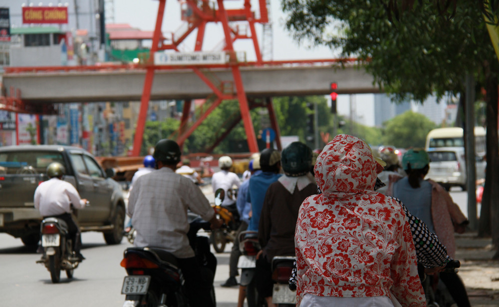 Nhiều người tham gia giao thông núp bóng cây chờ đèn đỏ. Ảnh: Trường Phong