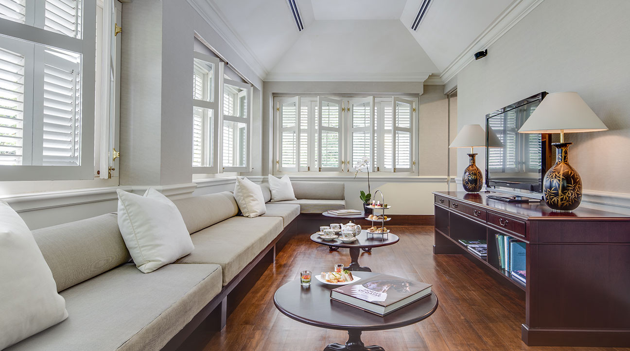 Phòng khách ở biệt thự Colonial Manor nổi bật với sàn ốp gỗ, ghế sofa bọc đệm trải dài gần hết căn phòng, phù hợp cho nhóm 6 người cùng sinh hoạt.