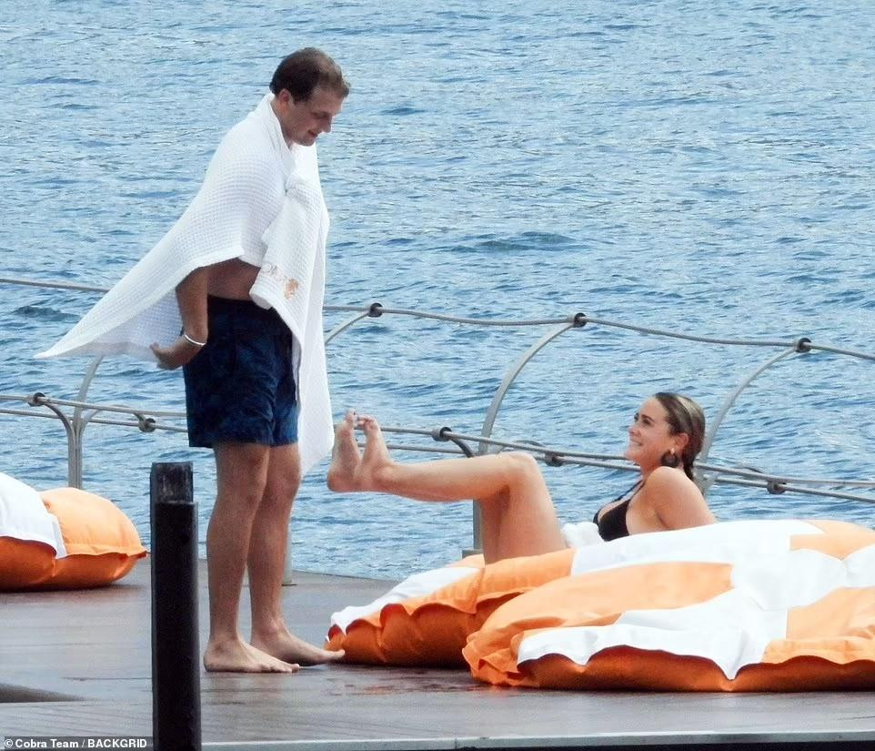 Cặp đôi đùa giỡn nhau trong lúc tắm nắng bên hồ Como.