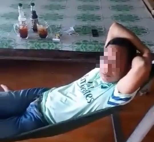 Trung tá P. nằm võng, không đeo khẩu trang khi đến nhà dân nắm tình hình. Ảnh cắt từ clip Trung tá P. nằm võng, không đeo khẩu trang khi đến nhà dân nắm tình hình. Ảnh cắt từ clip