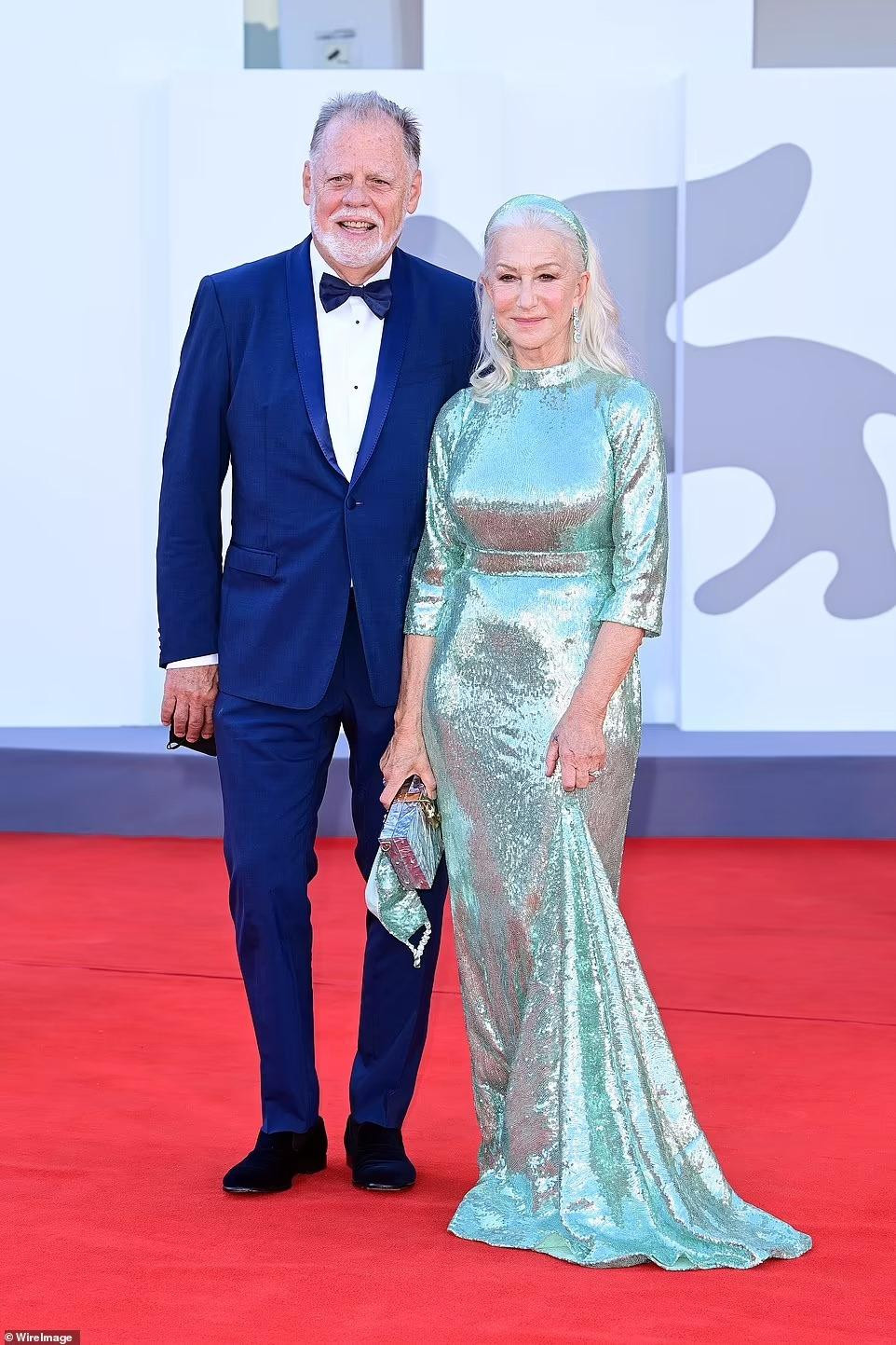 Minh tinh 76 tuổi Helen Mirren thanh lịch, quý phái trong chiếc váy dài màu bạc lấp lánh. Hộ tống bà là ông xã Taylor Hackford.