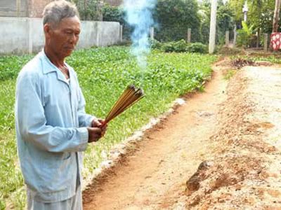 Ông Phạm Quang Tĩnh thắp hương trên nấm mộ chiêu hồn tập thể cai đội Phạm Quang Ảnh và các hùng binh Hoàng Sa