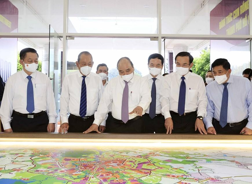 Chủ tịch nước xem xét bản đồ quy hoạch hai huyện Củ Chi, Hóc Môn. Ảnh: TTXVN