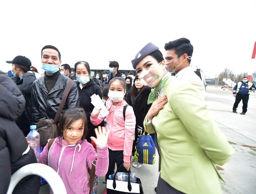 Các em nhỏ theo bố mẹ để trở về quê hương sau hành trình sơ tán từ Ukraine sang Ba Lan. Ảnh: Vietnamplus