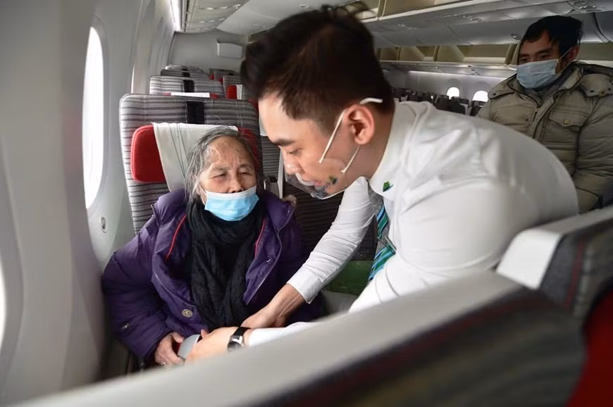 Một trường hợp khách bị yếu sức khỏe đã được tiếp viên hỗ trợ vào tận ghế ngồi. Ảnh: Vietnamplus