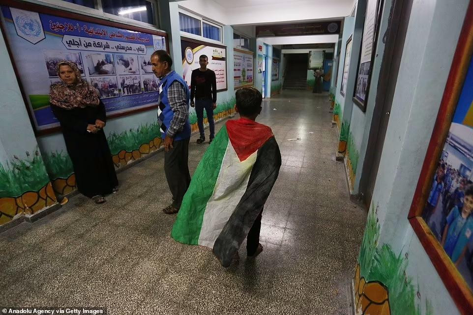 Một bé trai khoác quốc kì Palestine. Ảnh: AA