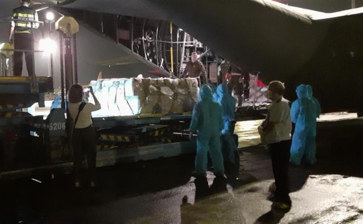 Lực lượng chức năng bốc dỡ lô hàng tại sân bay Tân Sơn Nhất.