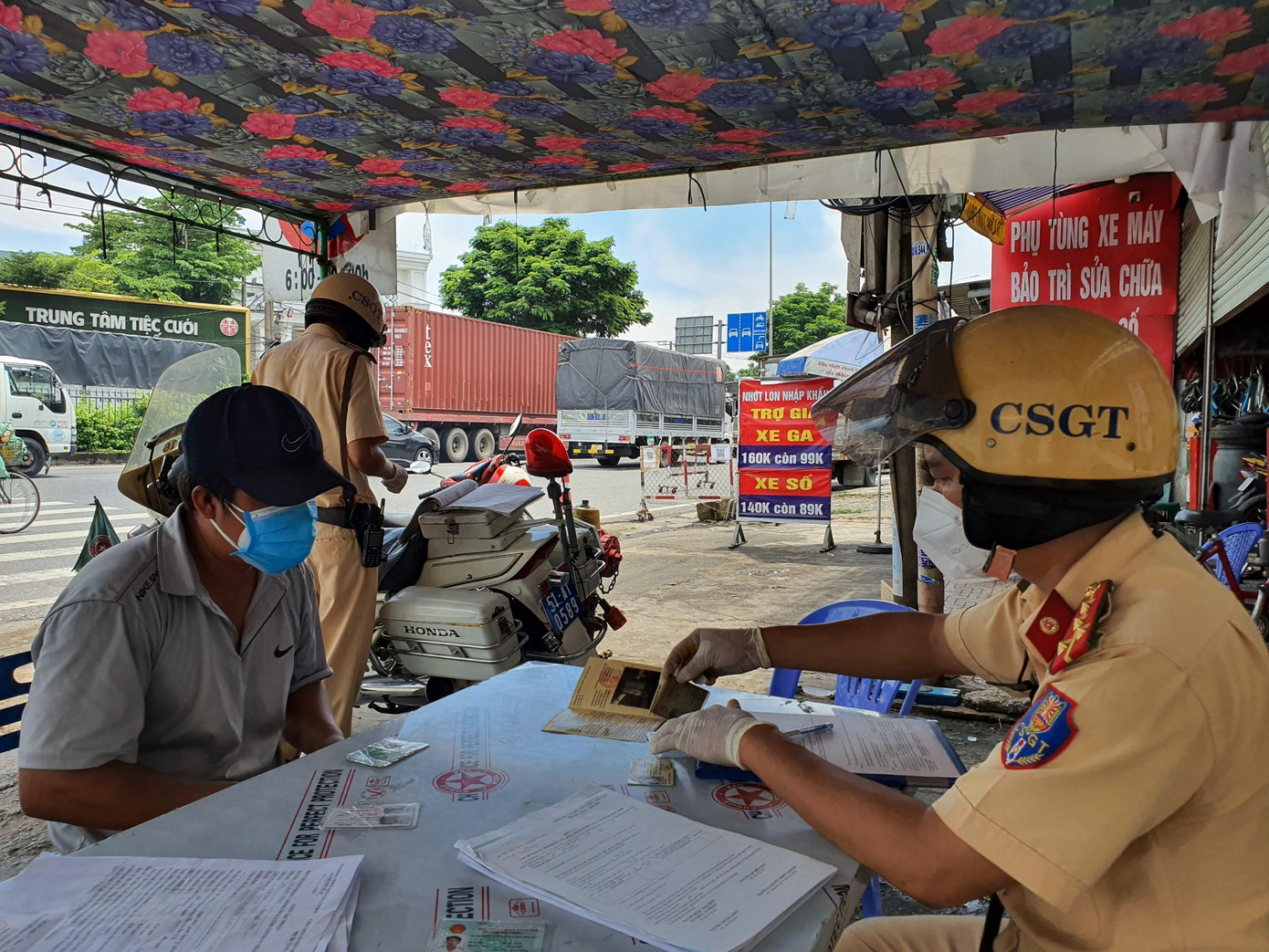 Lực lượng chức năng lập biên bản vi phạm với tài xế xe tải.