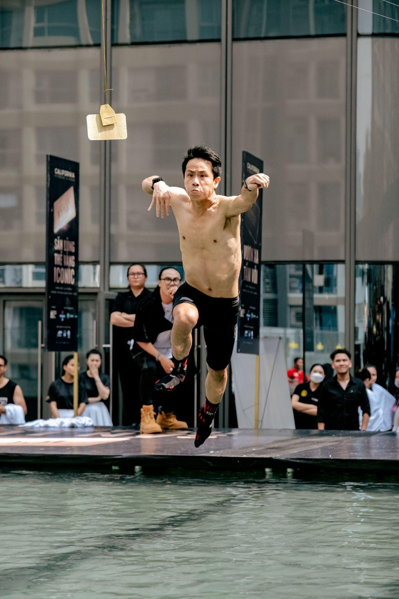 Với tên gọi “Vươn xa tầm với”, thử thách đầu tiên yêu cầu người chơi phải bật xa để bắt lấy tấm thẻ vàng treo ở giữa hồ bơi