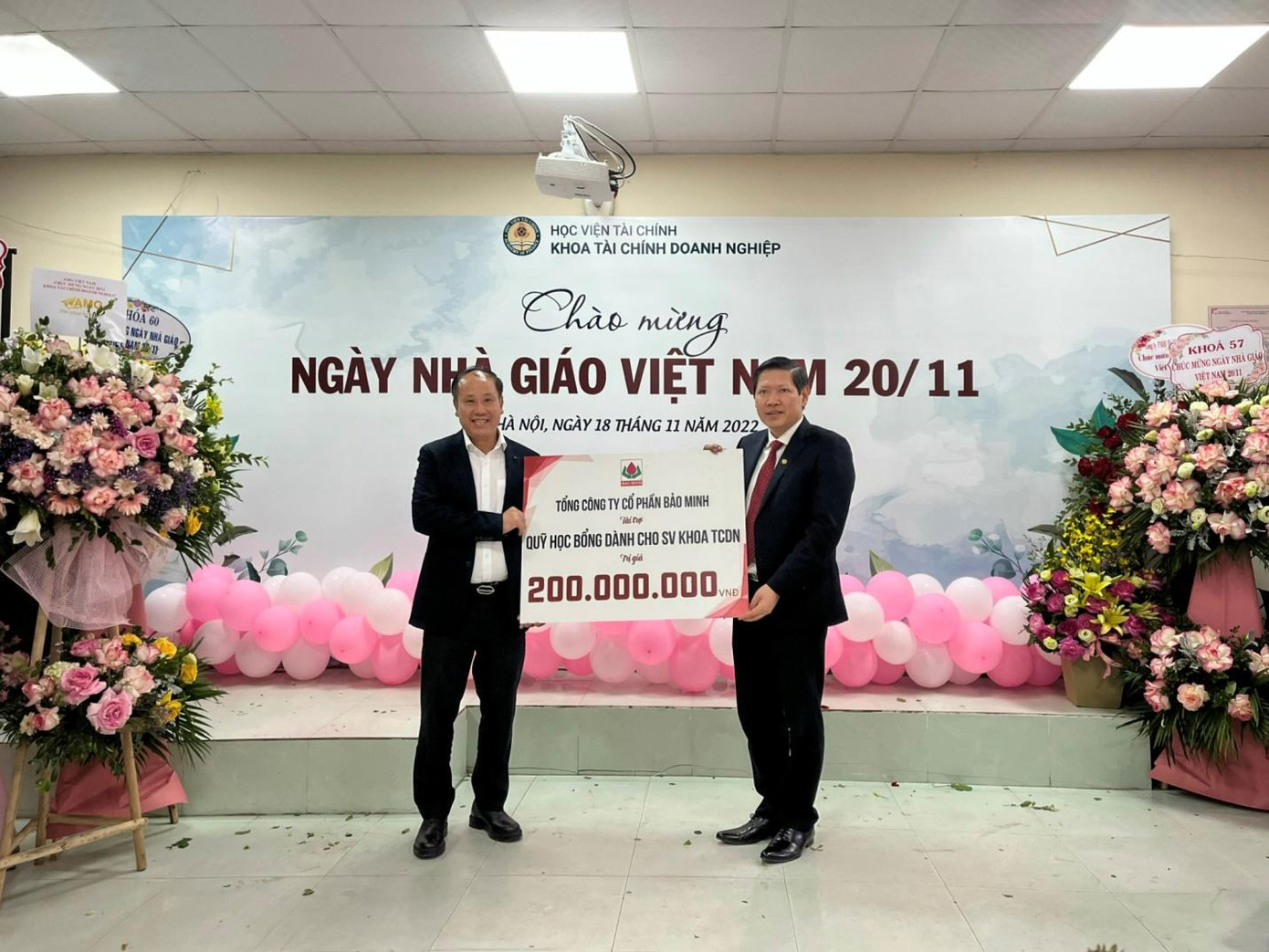 Ông Phạm Minh Tuân (bên trái) trao tặng 200 triệu đồng tài trợ cho Quỹ học bổng dành cho sinh viên khoa Tài chính Doanh nghiệp, Học viện Tài chính.