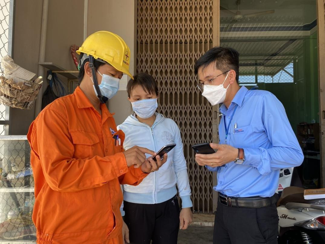 Nhân viên Điện lực hướng dẫn khách hàng sử dụng dịch vụ điện trực tuyến