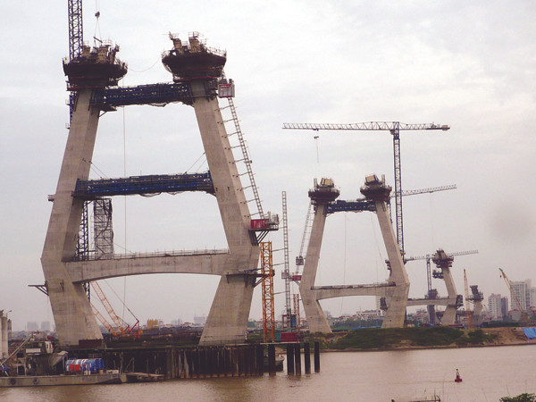 Cầu vượt sông Hồng lẽ ra phải hoàn thành tháng 10 tới nhưng nay các trụ mố vẫn sừng sững giữa sông. Ảnh: Trọng Đảng. Cầu vượt sông Hồng lẽ ra phải hoàn thành tháng 10 tới nhưng nay các trụ mố vẫn sừng sững giữa sông. Ảnh: Trọng Đảng