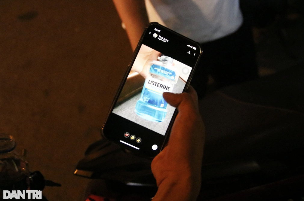 Anh H. cho cảnh sát xem lọ nước súc miệng mình vừa uống (Ảnh: Trần Thanh).