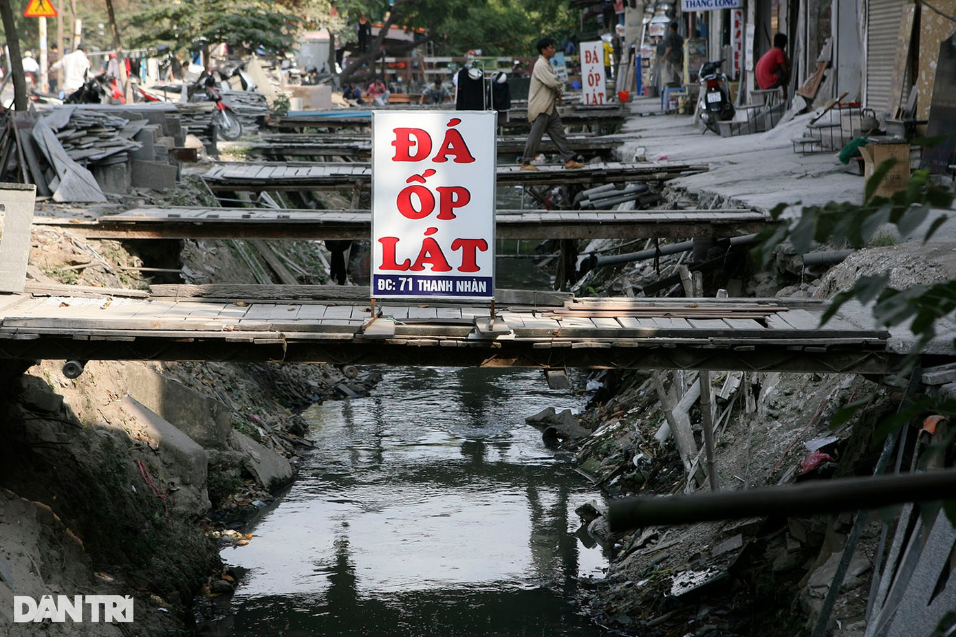 Phố Thanh Nhàn (quận Hai Bà Trưng) trước đây có lòng đường hẹp, chạy suốt theo tuyến phố là con mương nước thải ô nhiễm. Các hộ dân nơi đây phải tự bắc cầu để vào nhà.