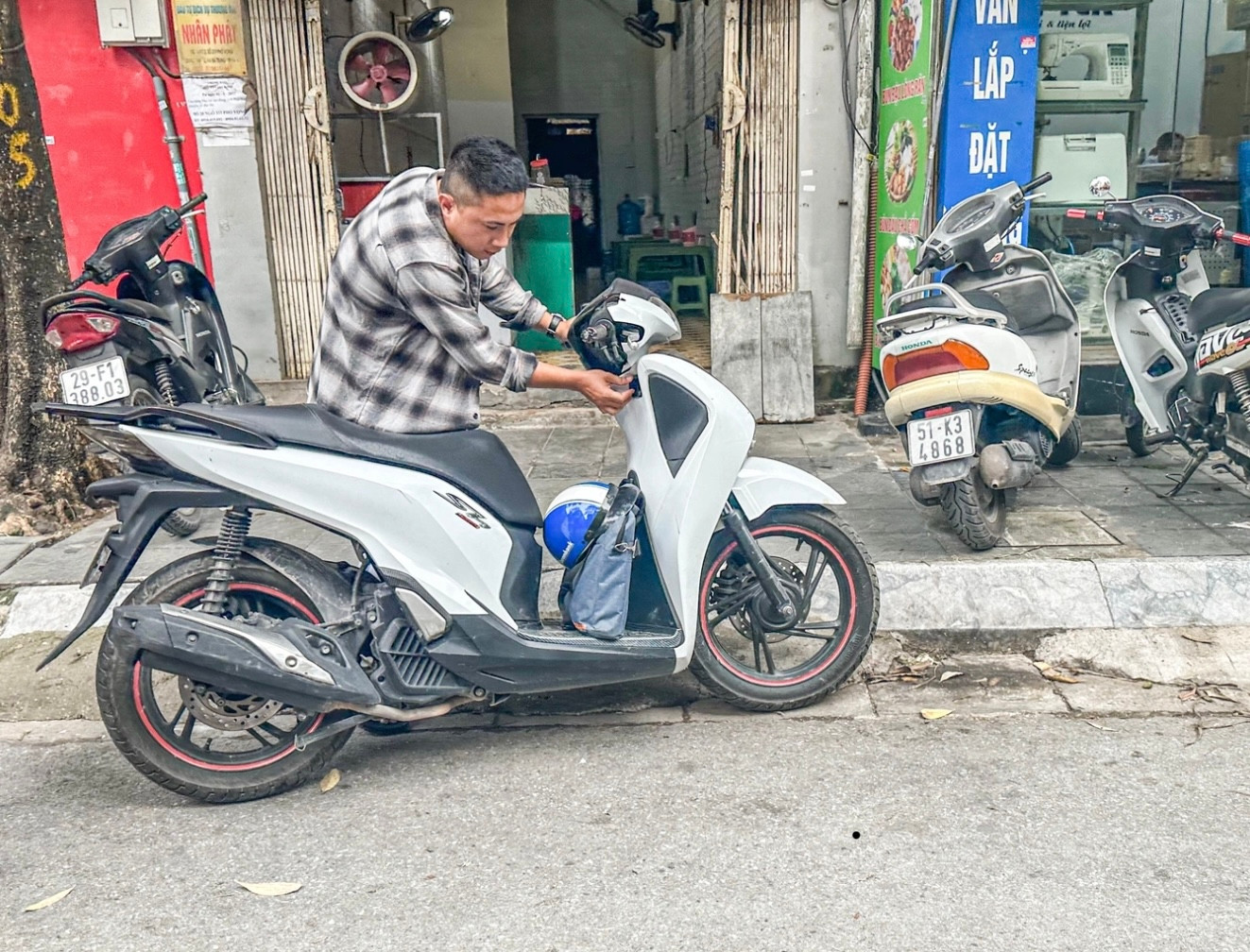 Anh Minh Hùng loay hoay đủ cách để có thể mở ổ khóa chiếc xe Honda SH 150i nhưng đều vô tác dụng. Sau đó, anh này dắt xe qua ngã 3 Nguyễn An Ninh - phố Vọng khoảng 100m thì xe mở được khóa, nổ máy bình thường (Ảnh: Nguyễn Hải).