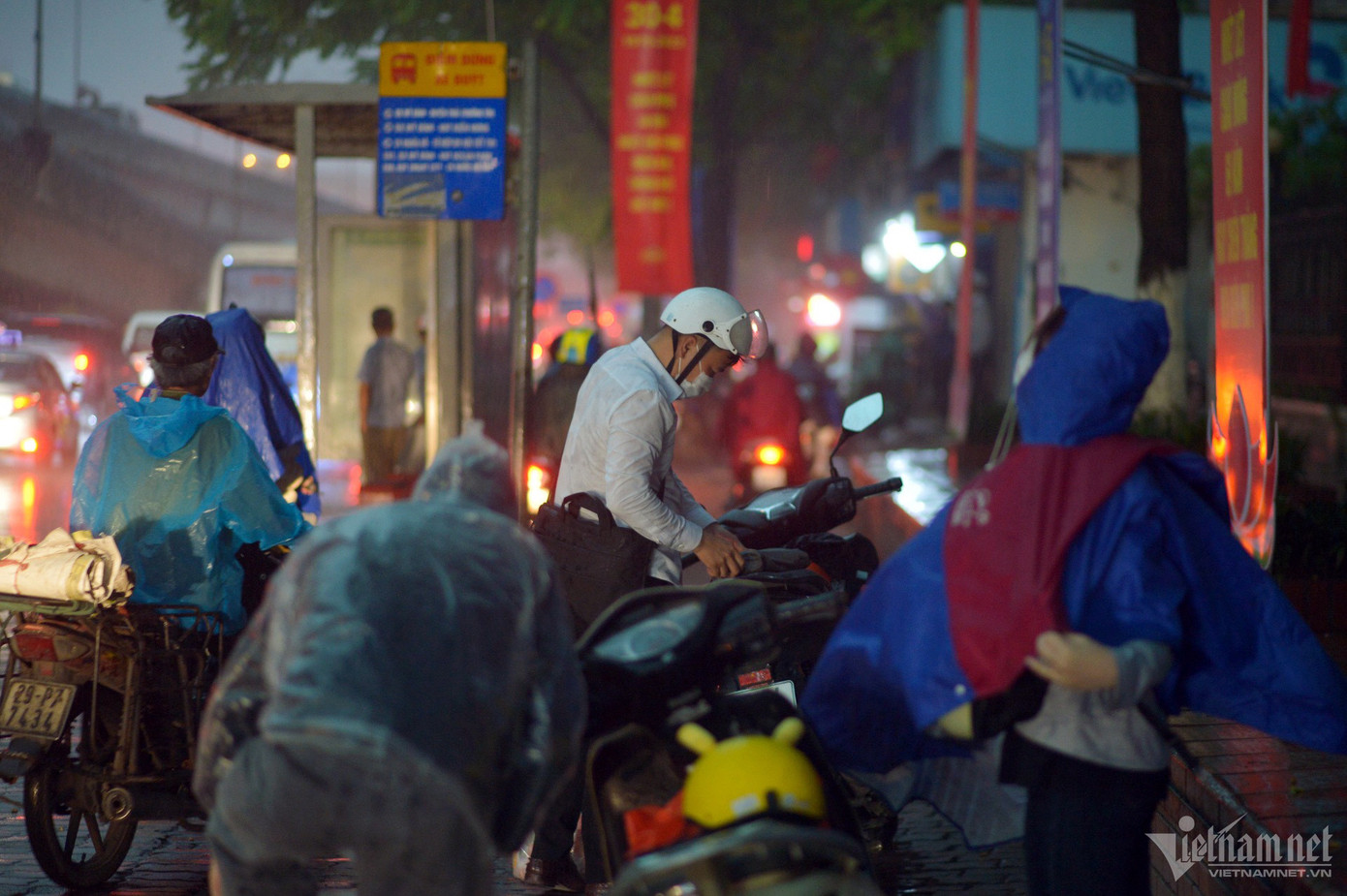 Nhiều người đi xe máy phải táp vào lề tìm chỗ trú. Hình ảnh tại đường Khuất Duy Tiến (quận Thanh Xuân).