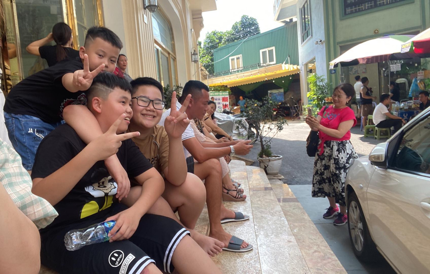 Cả đoàn ngồi chờ đợi bên ngoài khách sạn (Ảnh: NVCC) Cả đoàn ngồi chờ đợi bên ngoài khách sạn (Ảnh: NVCC)