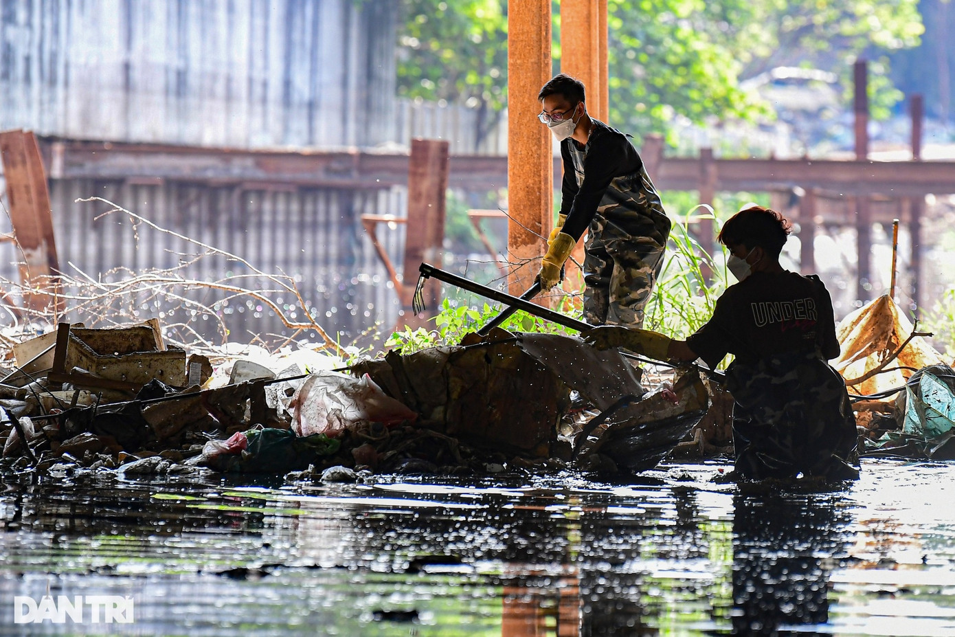 Tại những đoạn bùn đất dày đặc, tình nguyện viên dùng cào để bới rác, lưu thông dòng nước.