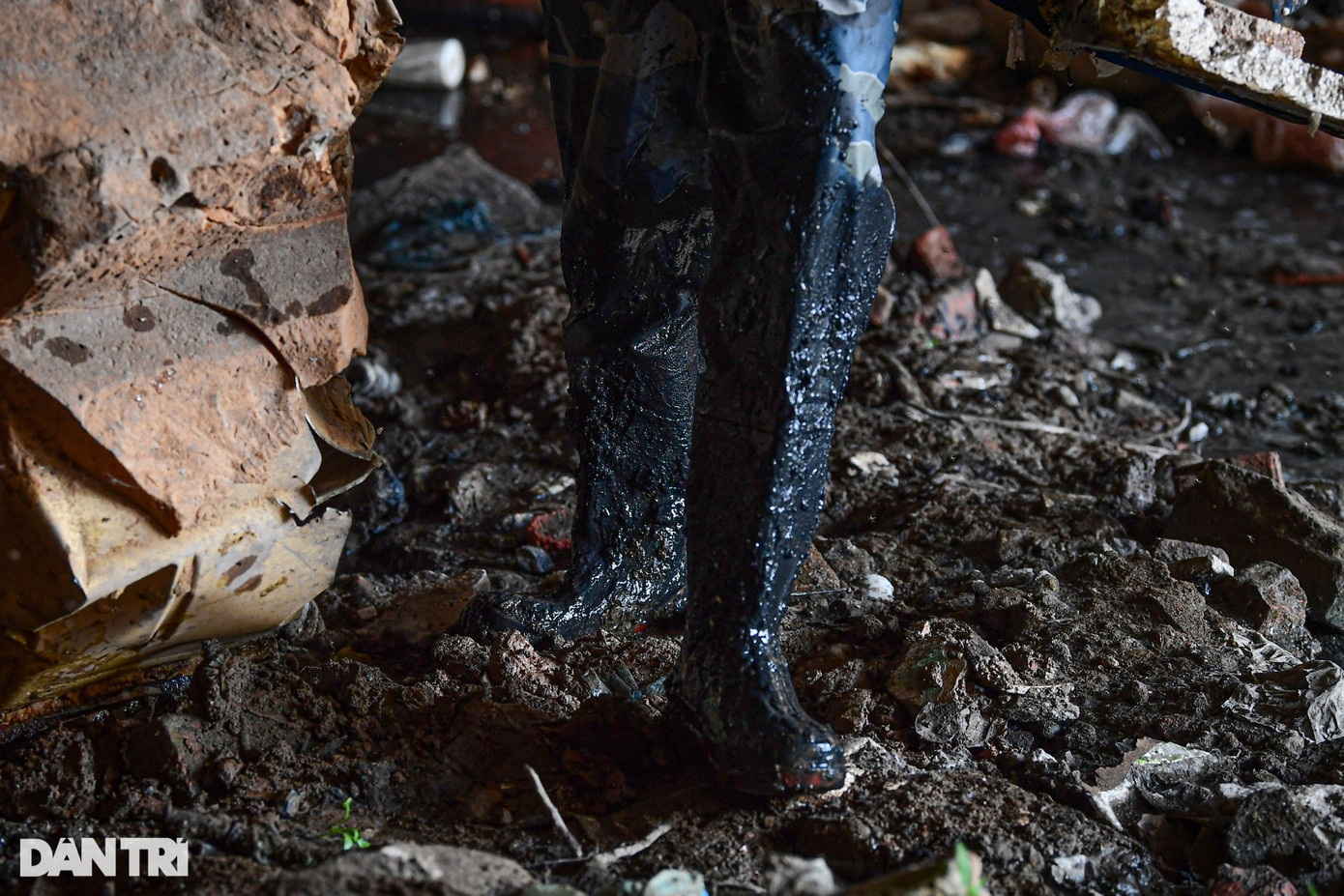 Những bộ quần áo bảo hộ bám đen nước thải và bùn đất sau nhiều tiếng ngâm mình dưới lòng kênh.