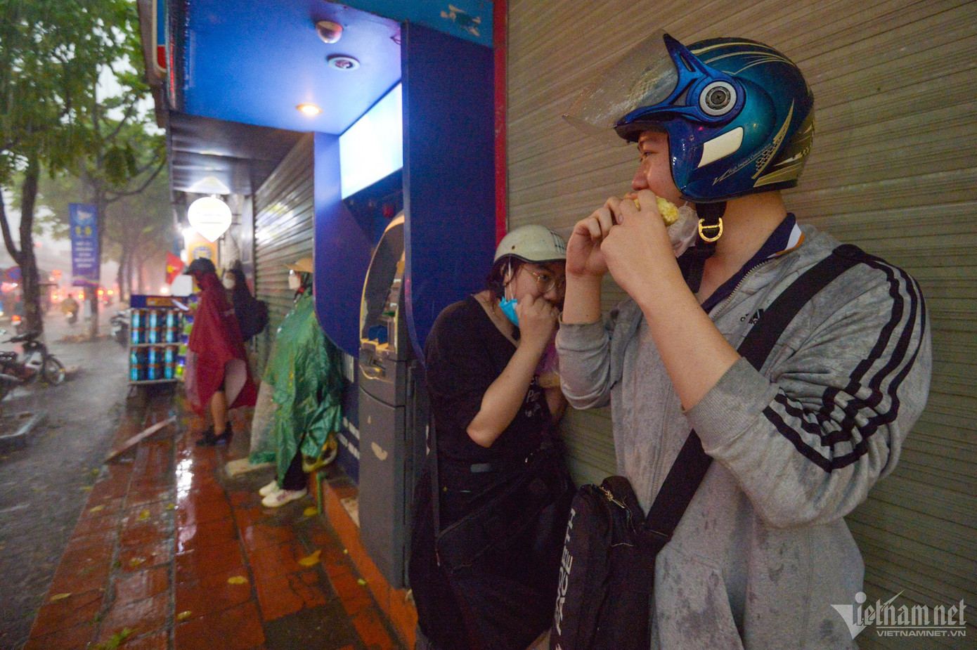 “Tôi đang trên đường ra bến xe Nước Ngầm để bắt xe về quê, đi được nửa đường gặp mưa nên đành trú tạm tại đây. Ban đầu tôi hơi chủ quan đã không xem thời tiết, bây giờ đành chịu đợi ngớt mưa mới có thể đi tiếp”, anh Phạm Hải Long vừa ăn bánh mì vừa nói.