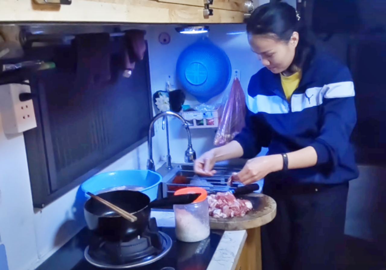 Chị Yên thích thú khi nấu ăn cho gia đình trong gian bếp nhỏ trên chiếc xe tải.