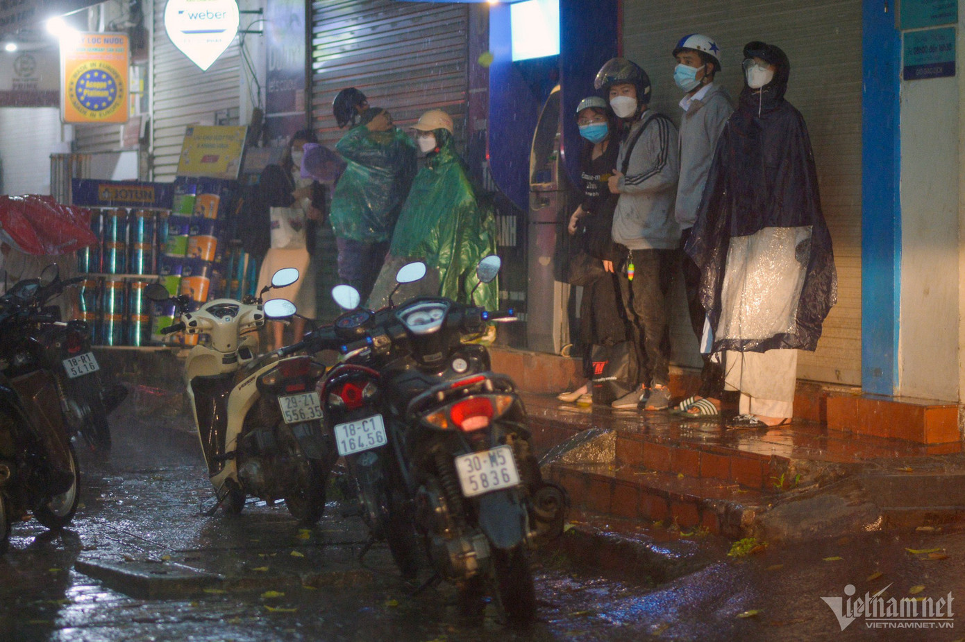 Người không mang áo mưa hay có mang nhưng áo mưa mỏng đều phải đứng dưới mái hiên đợi.