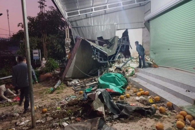 Chiếc ô tô tải đâm thủng tường chắn giữa 2 ngôi nhà (Ảnh: Xuân Trường).