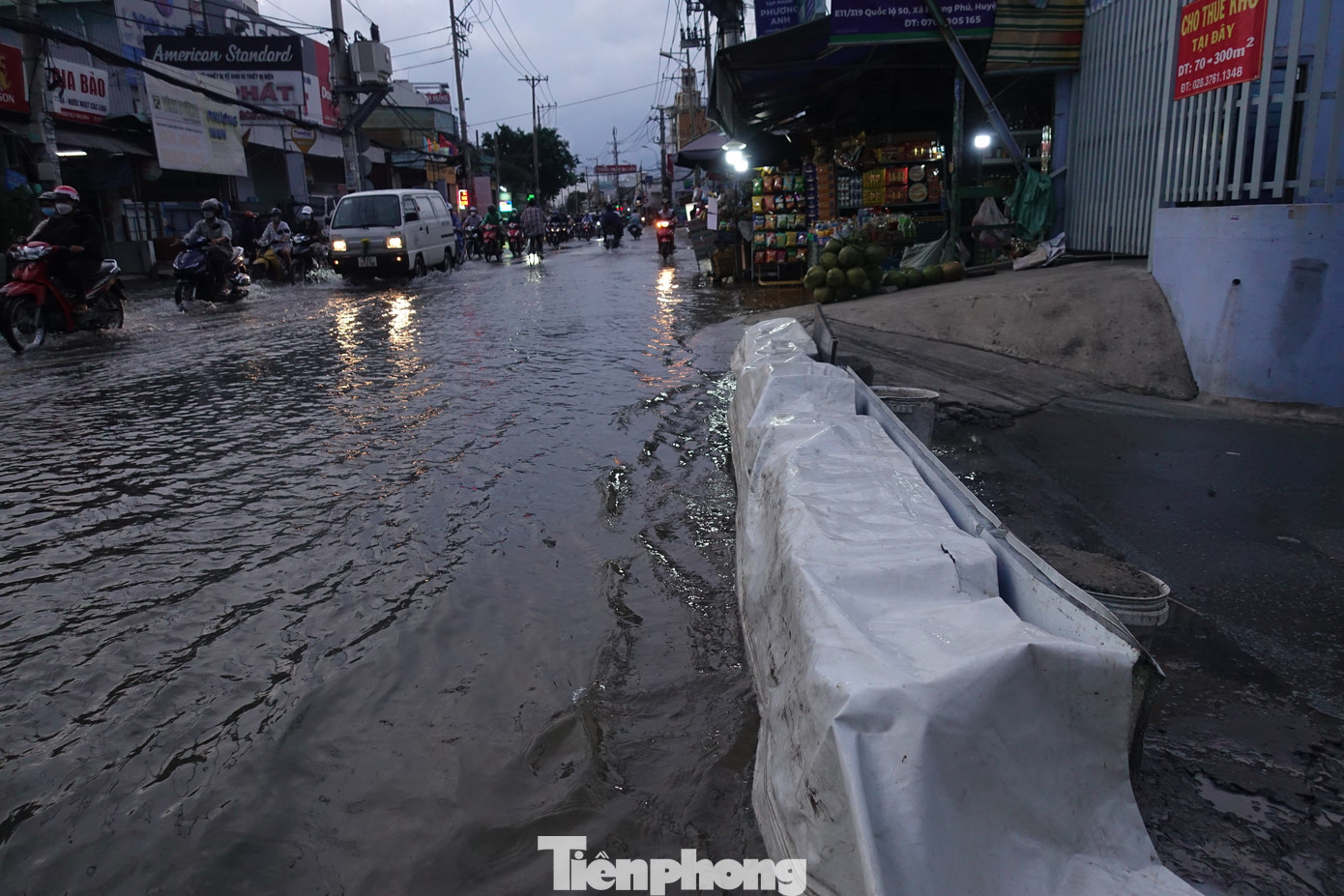 Người dân ở quốc lộ 50 (huyện Bình Chánh) phải dựng bờ ngăn nước tràn vào khu vực sinh sống.