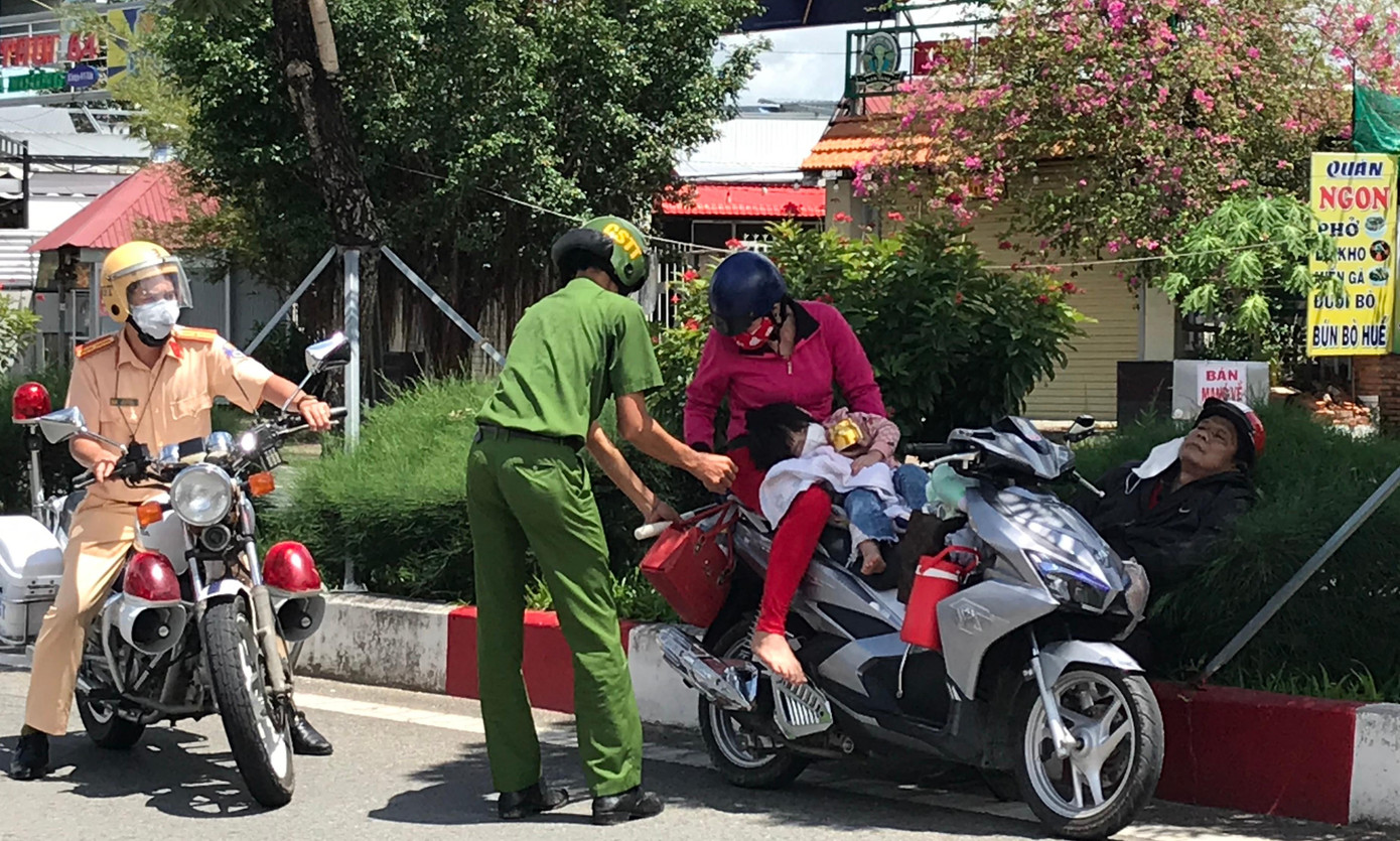 Vợ chồng người dân ở huyện Phú Tân ngất trên đường được lực lượng hỗ trợ để về quê