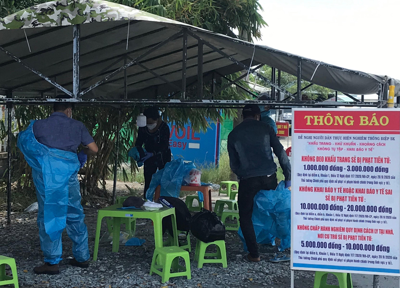 Người đi cách ly tập trung được trang bị bảo hộ cẩn thận trước khi lên xe chuyên dụng