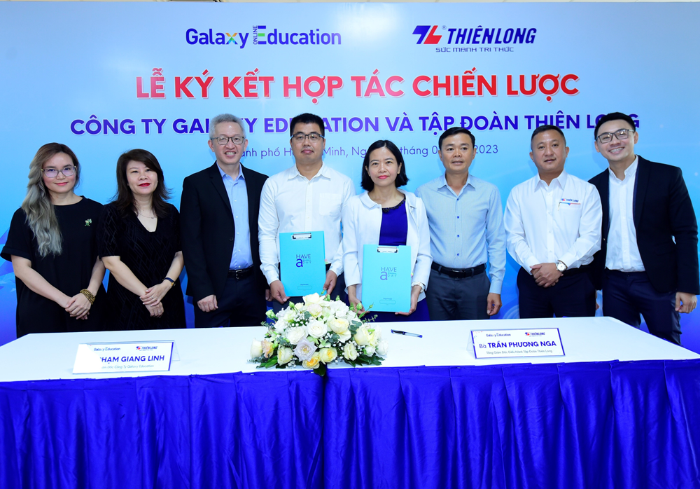Bà Trần Phương Nga, Tổng giám đốc điều hành Tập đoàn Thiên Long (áo khoác trắng, đứng giữa) và ông Phạm Giang Linh, Tổng giám đốc Công ty Galaxy Education (áo trắng, đứng thứ tư từ trái sang) cùng đại diện hai bên trong lễ ký kết.