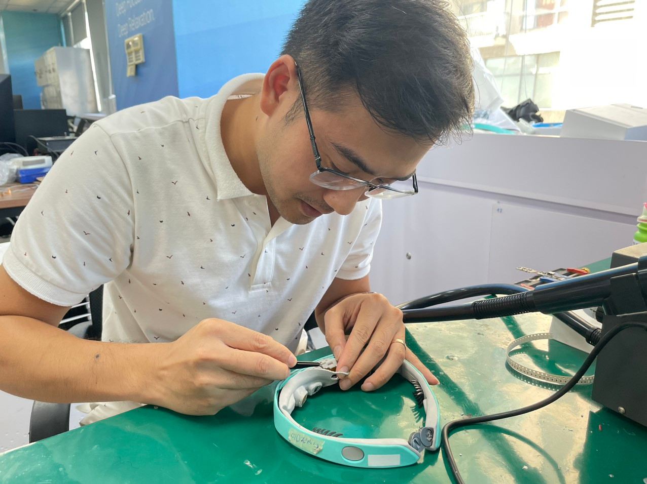 Anh Đinh Viết Hùng kỹ sư tại Earable đang kiểm tra mạch điện của vòng đeo FRENZ sau bài kiểm tra chống va đập. Ảnh T.H