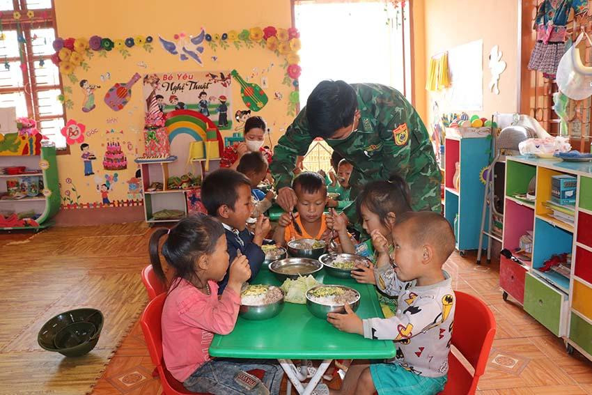 Cán bộ bộ đội biên phòng ân cần chăm lo bữa ăn cho các cháu.