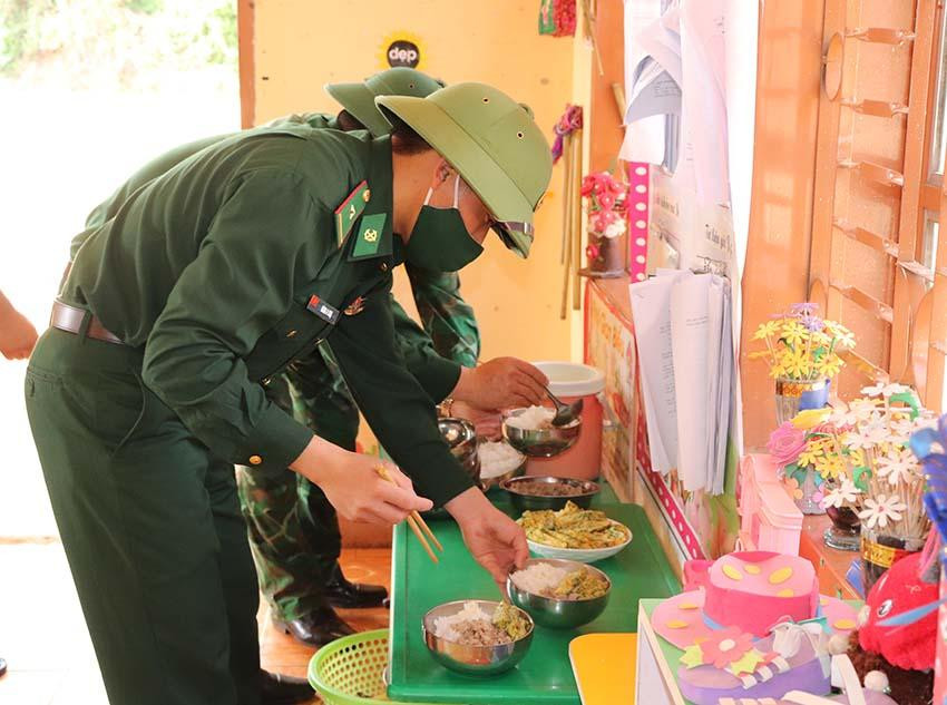 Bộ đội chia phần cơm cho các cháu.