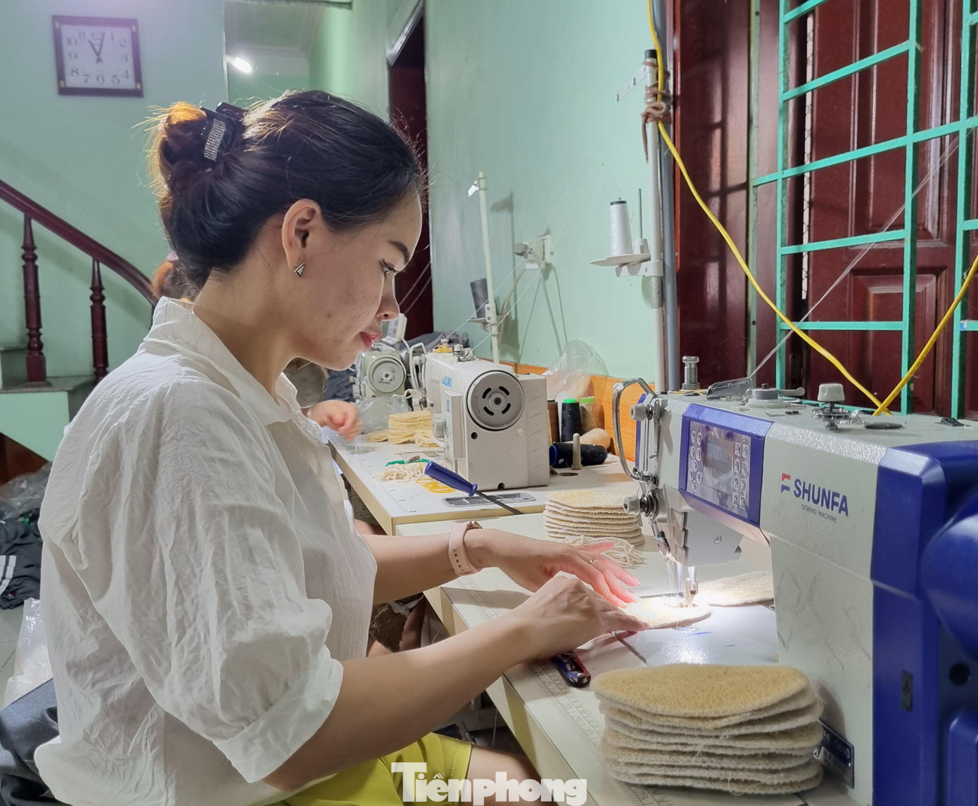 Tùy vào từng sản phẩm mà xơ mướp được cán dày hay mỏng. Với tiêu chí đặt ra là sản phẩm thân thiện môi trường nên khi sản xuất không dùng chất tẩy trắng hoặc ngâm hóa chất. - Ảnh: Công nhân may viền các sản phẩm từ xơ mướp.