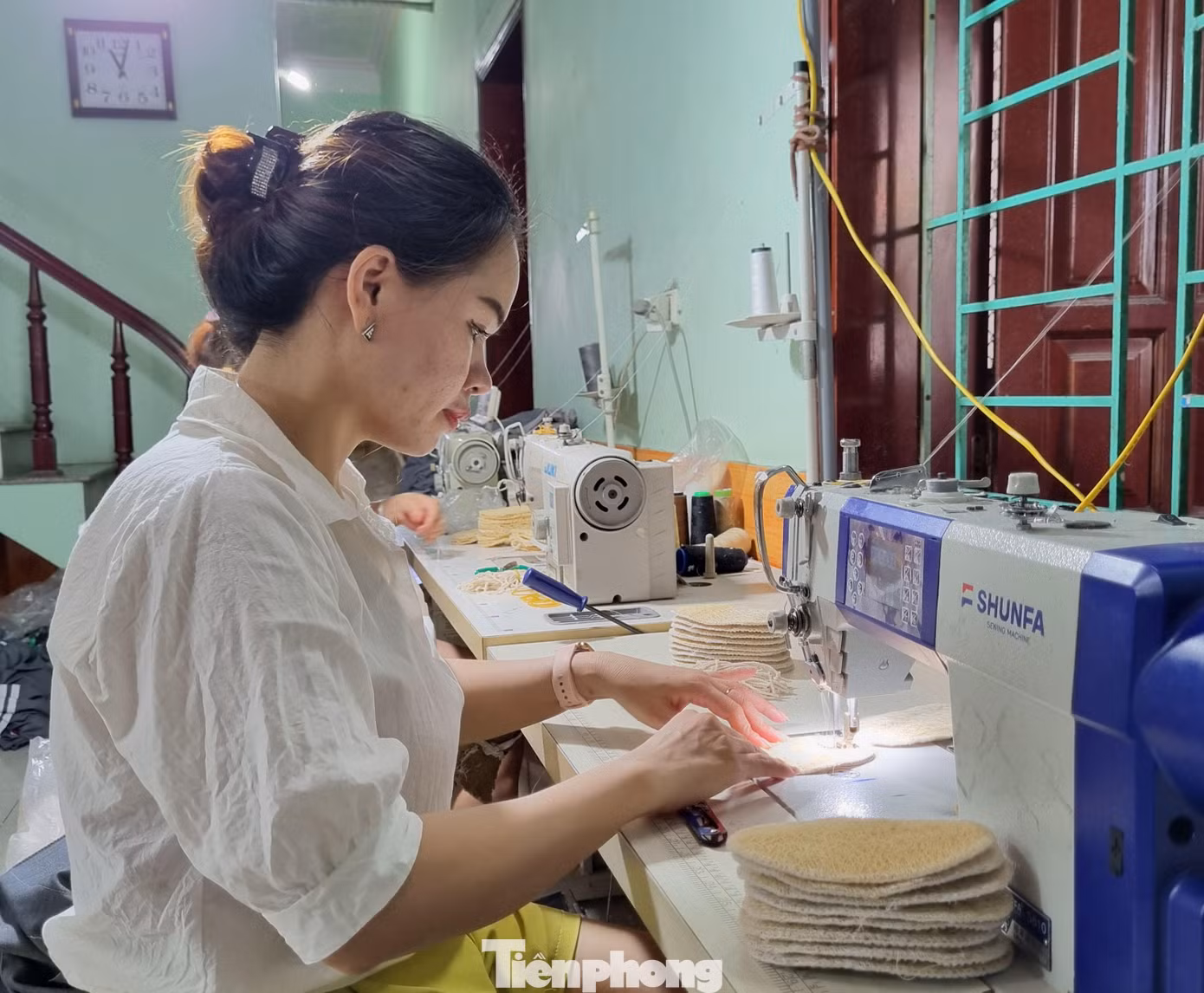 Tùy vào từng sản phẩm mà xơ mướp được cán dày hay mỏng. Với tiêu chí đặt ra là sản phẩm thân thiện môi trường nên khi sản xuất không dùng chất tẩy trắng hoặc ngâm hóa chất. - Ảnh: Công nhân may viền các sản phẩm từ xơ mướp.