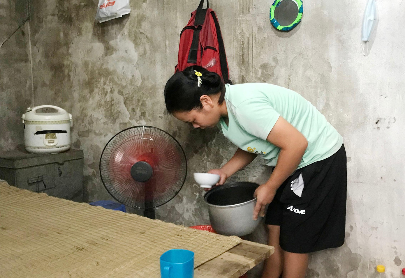 Nằm phía sau chợ đầu mối Long Biên (Hà Nội) là những phòng trọ xập xệ, mỗi phòng chỉ rộng 6 - 10m2. Hầu hết người thuê trọ đều làm nghề bốc vác, kéo xe, gánh hàng thuê ở chợ đầu mối Long Biên. Trong ảnh là phòng trọ của vợ chồng anh Lương Văn Tự, 36 tuổi, quê huyện Tam Đảo, tỉnh Vĩnh Phúc, làm nghề gánh hàng thuê. Căn phòng trọ hơn 6m2 của anh chị được lợp bằng tôn. Dưới cái nóng 40 độ C, căn phòng nóng như một lò lửa.