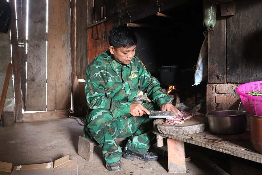 Đại úy Bàn Văn Vinh, nhân viên Tổ công tác Biên phòng bản Buốc Pát, Đồn Biên phòng cửa khẩu Lóng Sập thoăn thoắt thái thịt, chuẩn bị bữa cơm cho 13 cháu học sinh mầm non trong bản.