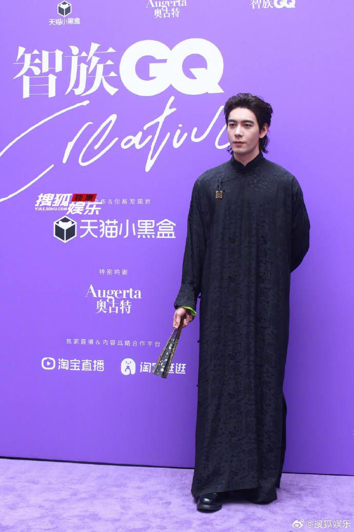 Diện mạo nam tính của Trần Tinh Húc trên thảm đỏ GQ. Nam diễn viên sử dụng phụ kiện quạt đen, họa tiết vàng giúp tạo hình cổ trang trở nên ấn tượng.