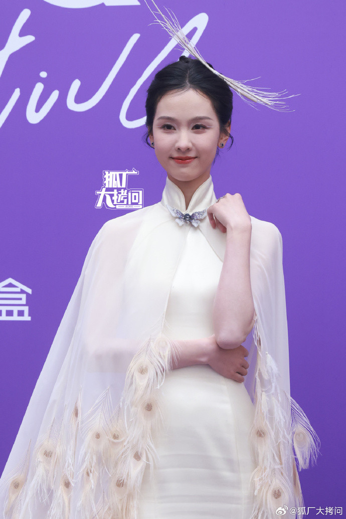 Trần Đô Linh hóa nàng tiên công màu trắng đầy cuốn hút. Trang phục sườn xám, áo choàng đính lông vũ cùng kiểu trang điểm mắt nhấn vào eyeliner màu trắng được khen ngợi hết lời.