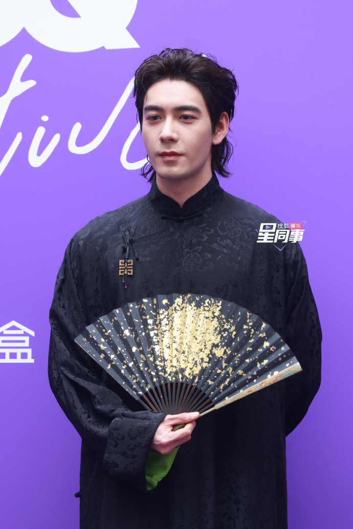 Diện mạo nam tính của Trần Tinh Húc trên thảm đỏ GQ. Nam diễn viên sử dụng phụ kiện quạt đen, họa tiết vàng giúp tạo hình cổ trang trở nên ấn tượng.