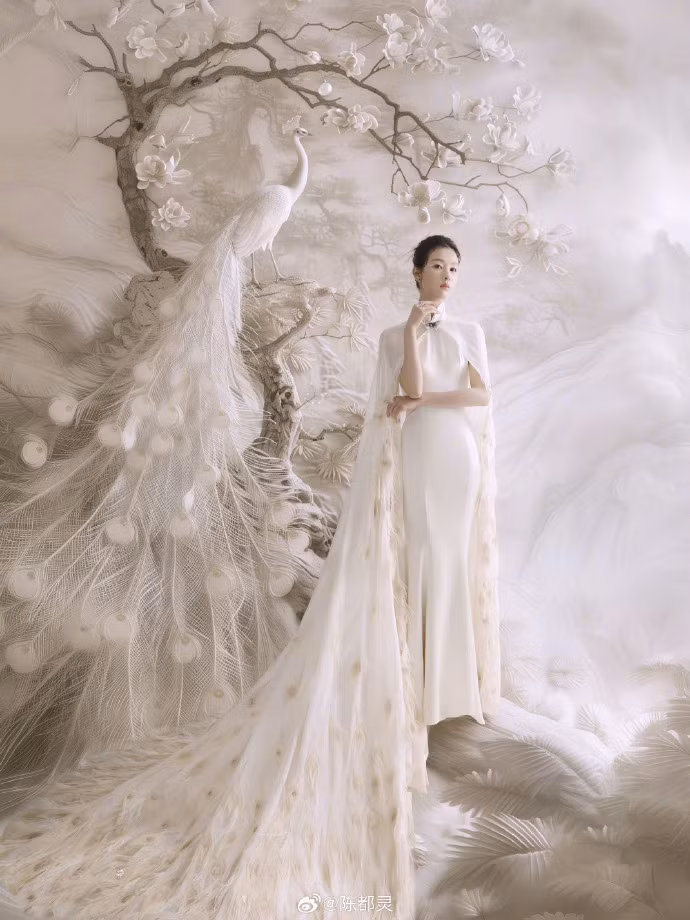 Trần Đô Linh hóa nàng tiên công màu trắng đầy cuốn hút. Trang phục sườn xám, áo choàng đính lông vũ cùng kiểu trang điểm mắt nhấn vào eyeliner màu trắng được khen ngợi hết lời.