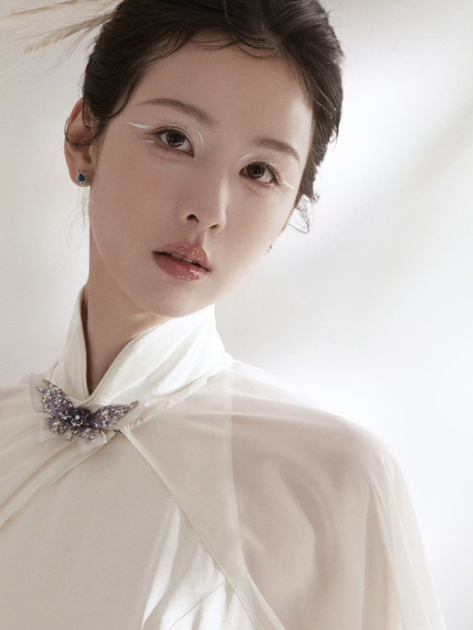 Trần Đô Linh hóa nàng tiên công màu trắng đầy cuốn hút. Trang phục sườn xám, áo choàng đính lông vũ cùng kiểu trang điểm mắt nhấn vào eyeliner màu trắng được khen ngợi hết lời.