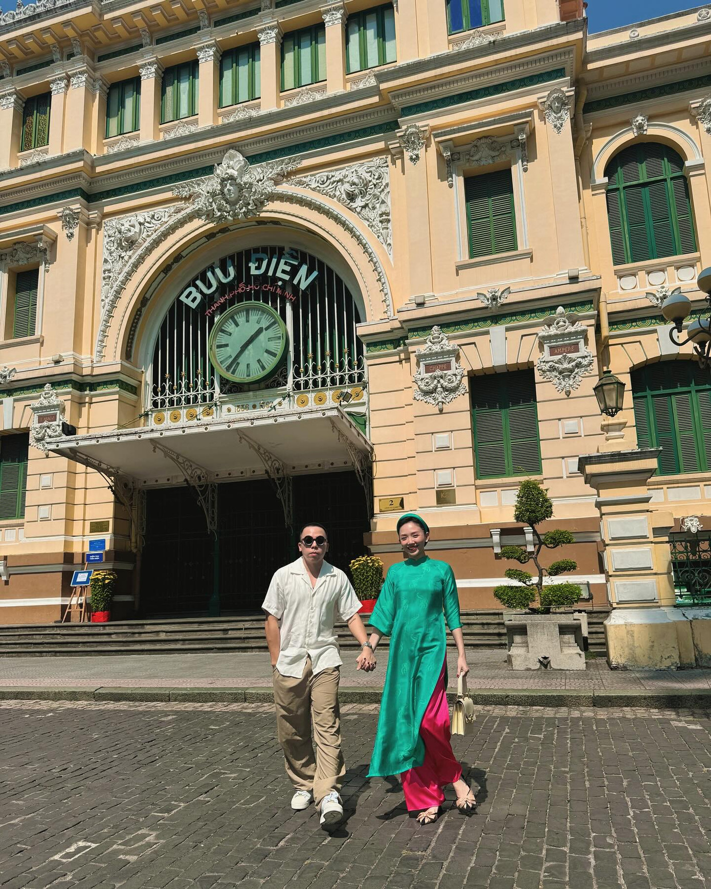 Tóc Tiên trẻ trung với tà áo dài dáng suông màu xanh, kết hợp với quần màu hồng nổi bật.