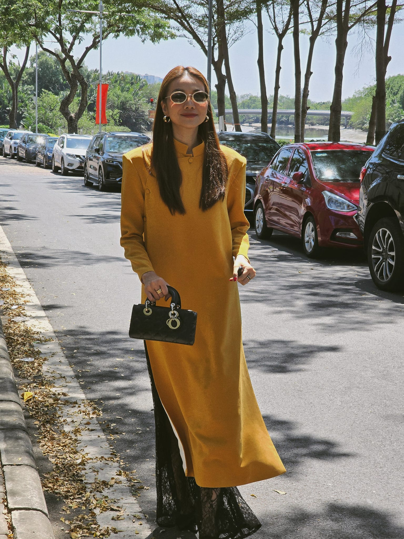 "Chị đại" Thanh Hằng duy trì phong độ thời trang Tết ấn tượng. Trong ngày đầu năm, nữ siêu mẫu khoe sắc đằm thắm trong tà áo dài suông màu tím. Sang mùng 2, Thanh Hằng sành điệu với áo dài cổ trụ màu vàng, mix&amp;match cùng kính râm oval và túi xách Dior.