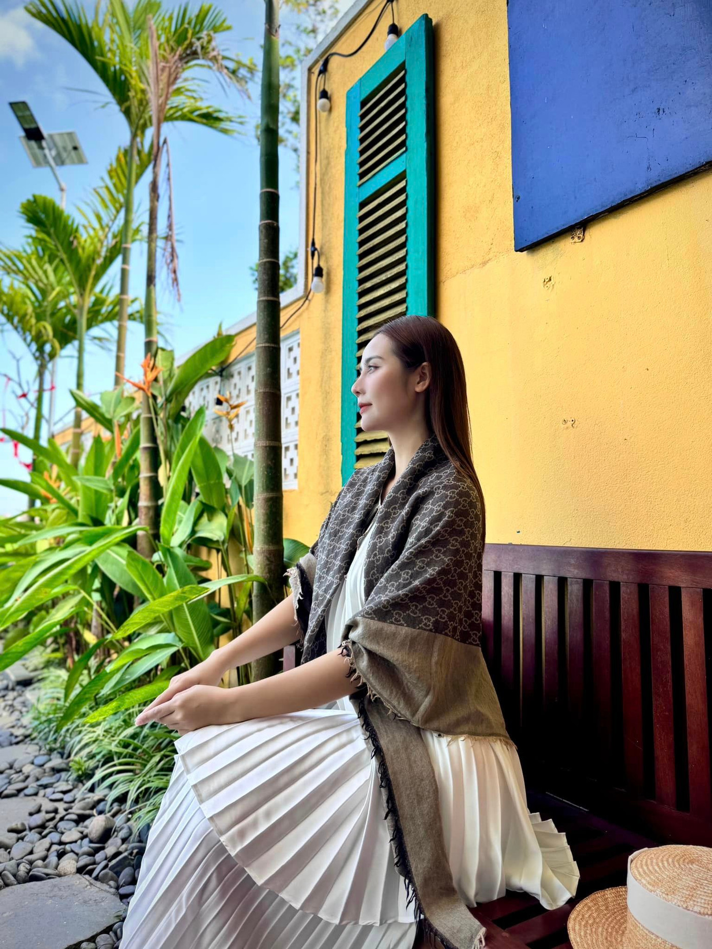 Huyền Lizzie đằm thắm trong chiếc đầm cổ yếm xếp ly, phối cùng khăn choàng to bản của thương hiệu Gucci.