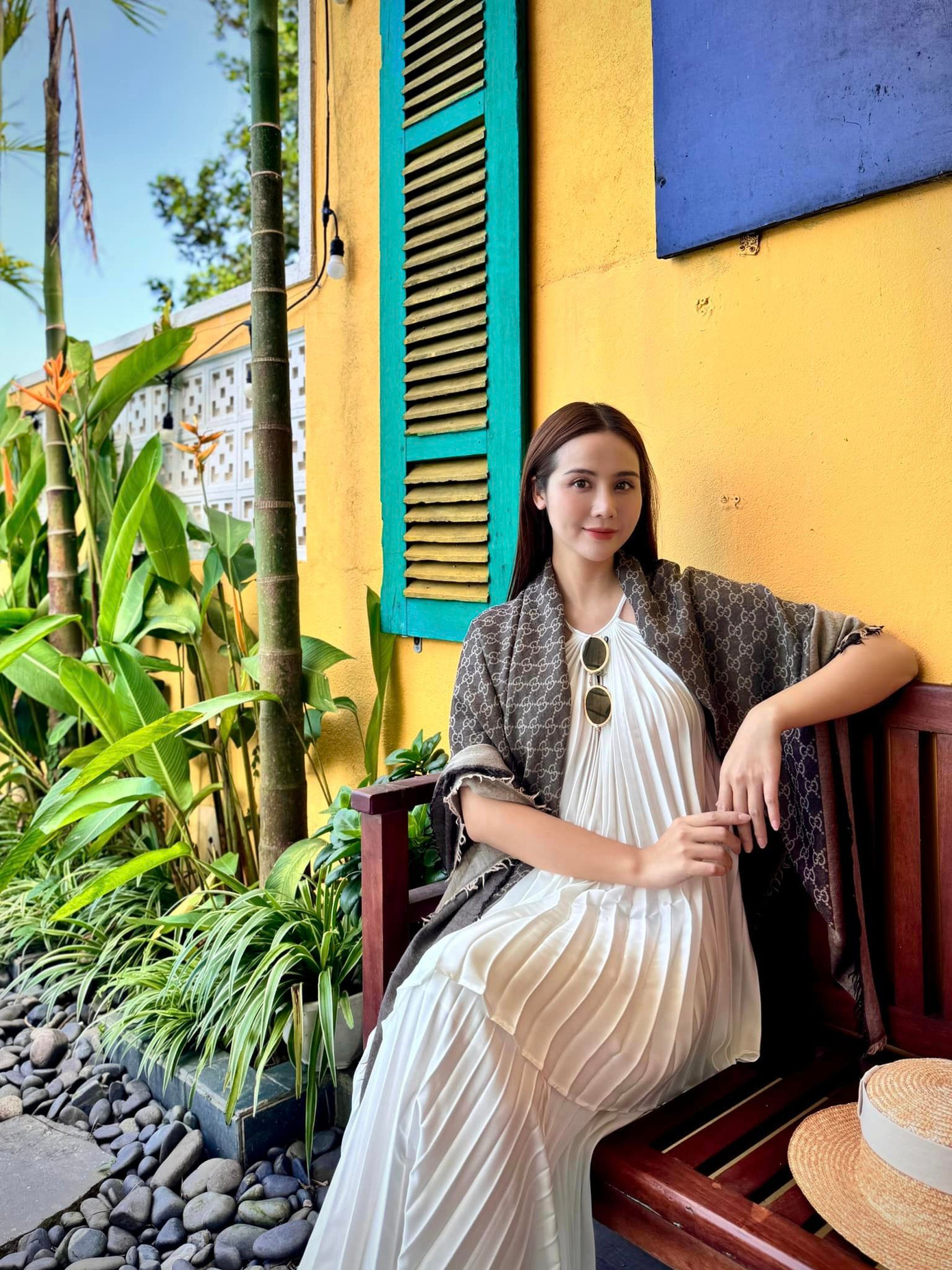 Huyền Lizzie đằm thắm trong chiếc đầm cổ yếm xếp ly, phối cùng khăn choàng to bản của thương hiệu Gucci.