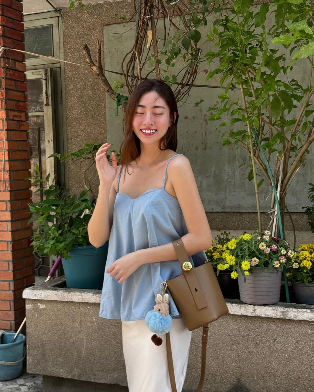 Hoa hậu Lương Thùy Linh có cách mix &amp; match thú vị với các mẫu áo hai dây, bra-top. Người đẹp mang đến cảm giác dịu dàng khi phối áo hai dây dáng dài cùng chân váy và túi xách hot trend. Khi ra biển, nàng hậu diện bra-top kết hợp cùng áo sơ mi và mũ bucket trẻ trung.